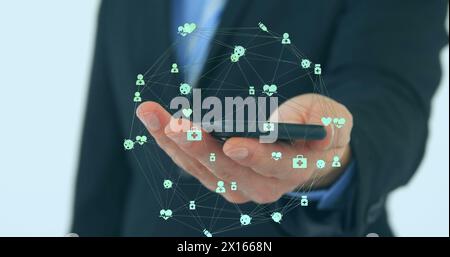 Image of globe of connections with icons over businessman using smartphone Stock Photo