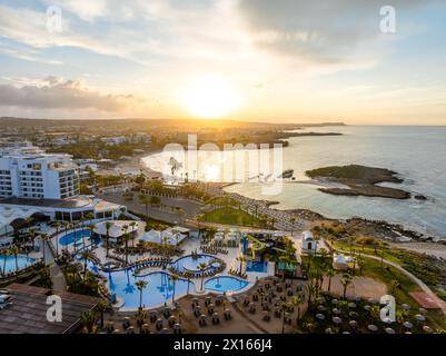 Experience the serene sunrise at Nissi Beach, Cyprus, ideal for holiday resorts, tranquil sea views, and leisure travel. A premier Mediterranean desti Stock Photo