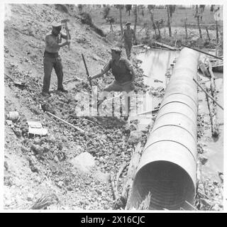 ITALY : CLEARING A ROAD THROUGH CASSINO - Laying zinc gullies for drainage purposes in bomb craters on the railroad near the station British Army Stock Photo