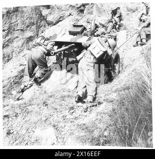 Soldiers haul an anti-tank gun across a river under the British Army ...