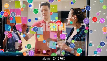 Image of colorful circles with icons and numbers, diverse coworkers discussing over sticky notes Stock Photo