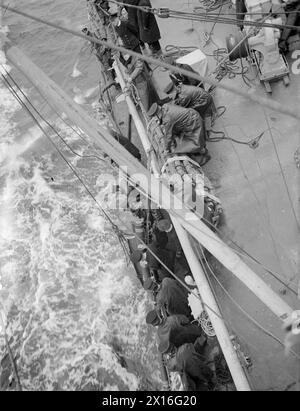 CRUISER REFUELLING AT SEA. SEPTEMBER 1944, ON BOARD HMS JAMAICA AT SEA, REFUELLING FROM A TANKER. - The hoses about to be passed through a trough Stock Photo