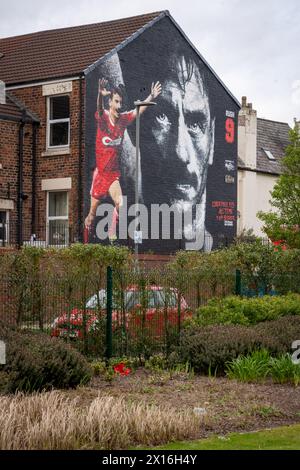 Merchandise selling beneath the Ian Rush mural outside Anfield football stadium, Liverpool Stock Photo