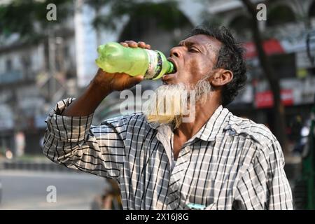 A rickshaw driver is drinking water from a roadside water pipeline ...