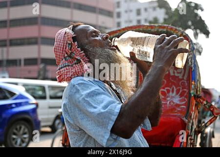 A rickshaw driver is drinking water from a roadside water pipeline ...