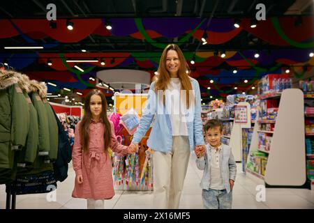 Portrait of happy mother with little children in shopping mall Stock Photo