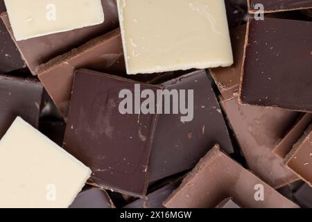 mixed together different types of chocolate, white, bitter and milk chocolate pieces Stock Photo