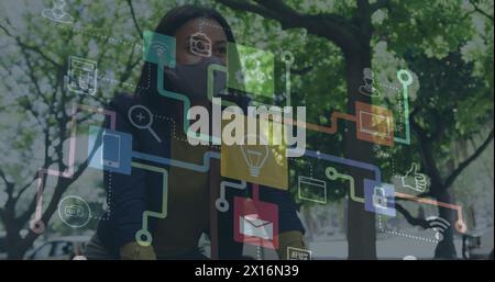 Image of colorful social media notifications and computer icons over woman riding bicycle Stock Photo