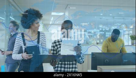 Image of financial code data over diverse female coworkers talking in office Stock Photo