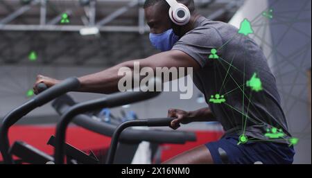 Image of network of connections with icons over african american man at gym Stock Photo