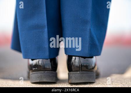 A pair of polished black shoes with a blue stripe on the side. The shoes are worn by a person in a military uniform Stock Photo