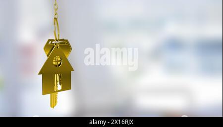 Image of gold house key fob and key dangling over out of focus interiors with copy space Stock Photo