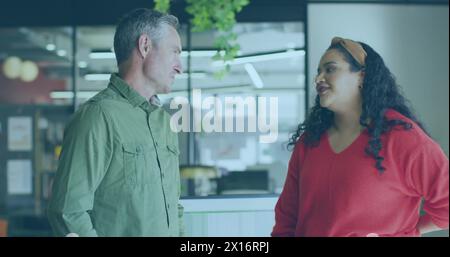 Image of data processing over diverse male and female colleagues discussing at office Stock Photo