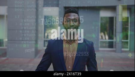 Image of numbers and data processing over african american businessman smiling on the street Stock Photo