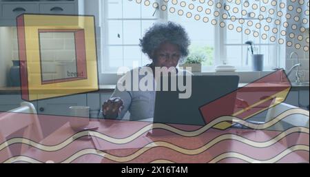 Image of shapes over senior african american woman using laptop Stock Photo