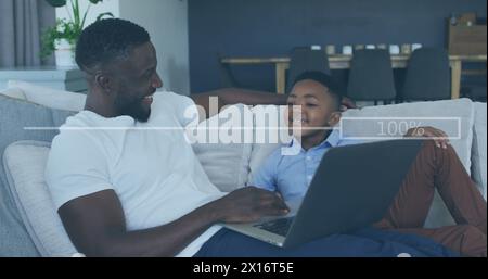 Image of increasing percentage over african american father and son using laptop at home Stock Photo
