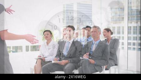 Image of clock and data processing over diverse business people Stock Photo