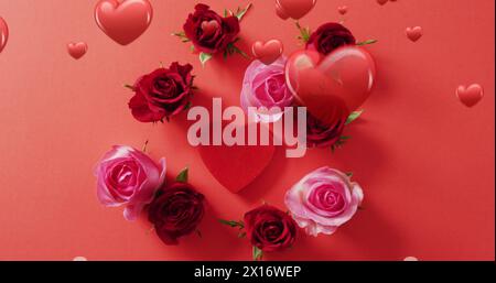 Image of red hearts over roses on red background Stock Photo