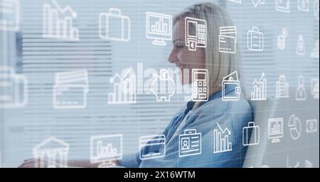 Image of multiple icons over caucasian woman working on laptop in office Stock Photo