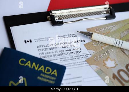 Application for Canadian citizenship for adults on table with pen, passport and dollar bills close up Stock Photo