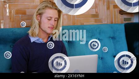 Image of graph icon in circles over caucasian man picking up cellphone while working on laptop Stock Photo