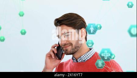 Image of connected icons globe over caucasian man standing and talking on smartphone Stock Photo