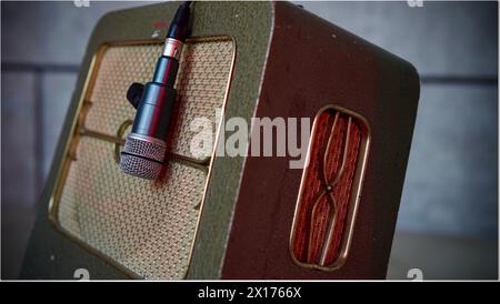 An old guitar amplifier with a microphone on stage. Stock Photo