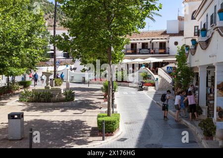 Tourists walk on a pleasant square surrounded by shops and restaurants in the mountain village of Mijas, Andalusia; Costa del Sol, Spain. Stock Photo