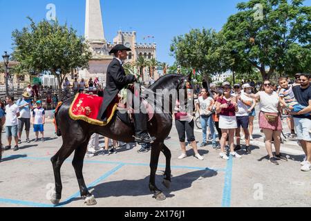 Riders and horses at the religious festival Festa de Sant Joan among the enthusiastic crowd in Ciutadella de Menorca in Spain. Stock Photo