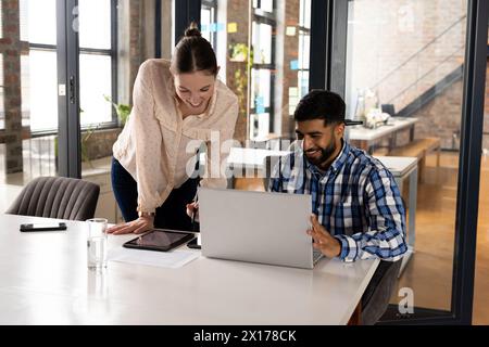 Caucasian female and Asian male colleagues are working together in a modern business office Stock Photo