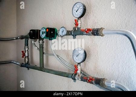 Water supply and heating pipes with pressure sensors and manometers. Construction and renovation of buildings, old water canals. Stock Photo