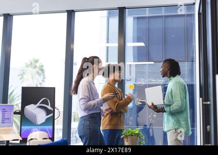 Diverse team discussing VR graphs in office Stock Photo