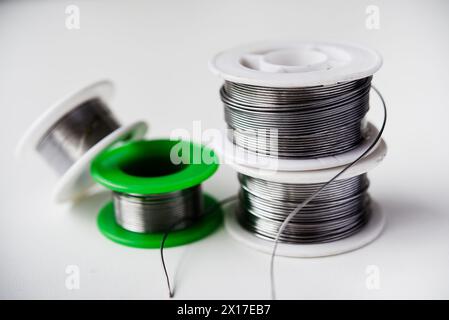 Tin-lead solder in coils on a white background. Materials for soldering. Stock Photo