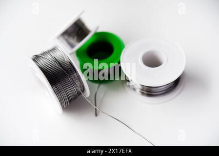 Tin-lead solder in coils on a white background. Materials for soldering. Stock Photo