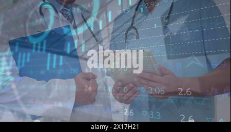 Image of statistics and data processing over midsection of caucasian male doctors Stock Photo