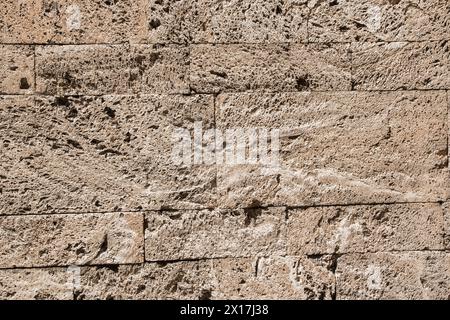 Stone wall of limestone bricks with spongy surface closeup as stone background Stock Photo