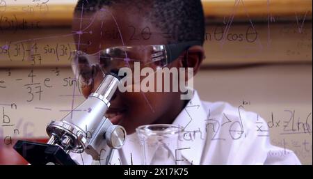 Image of mathematical formulae over smiling schoolboy using microscope Stock Photo