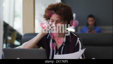 Image of hearts over caucasian businessman talking on smartphone Stock Photo