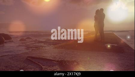 Image of light spots over african american couple at beach Stock Photo