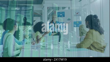 Image of graphs and numbers over diverse coworkers discussing ideas at office Stock Photo