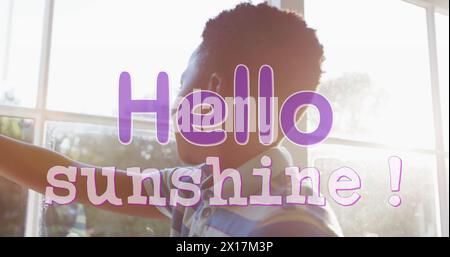 Image of hello sunshine text in purple over african american boy drawing curtains on sunny day Stock Photo