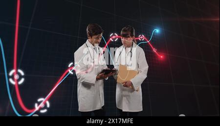 Image of financial graphs over caucasian female and male doctors Stock Photo