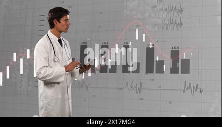 Image of financial data and graphs over caucasian male doctor Stock Photo