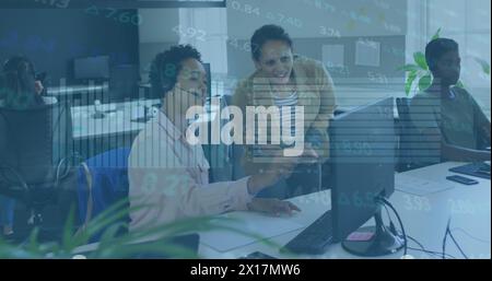 Image of stock market data processing over two diverse women discussing over computer at office Stock Photo