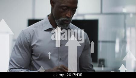 Image of arrows and data processing over african american businessman in office Stock Photo
