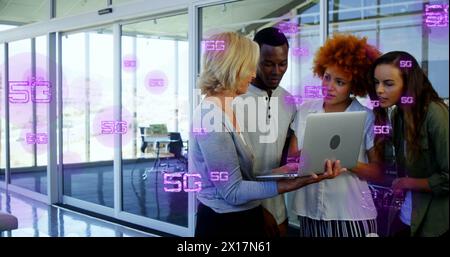 Image of multiple 5g texts over diverse coworkers discussing reports on laptop in office Stock Photo