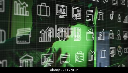 Multiple digital icons moving against asian man wearing vr headset Stock Photo