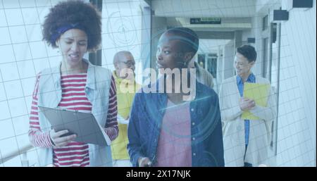 Image of fingerprint scanning over multiracial colleagues discussing, walking in office corridor Stock Photo