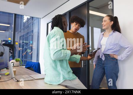 Diverse group of colleagues discussing in office, African American man holding tablet Stock Photo