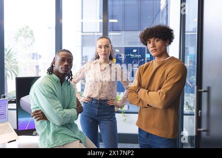 Diverse team standing in office, looking at camera Stock Photo